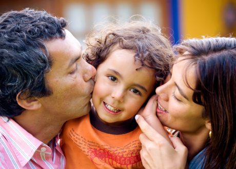 bigstockphoto_Parents_Kissing_Son_Portrait_2233187